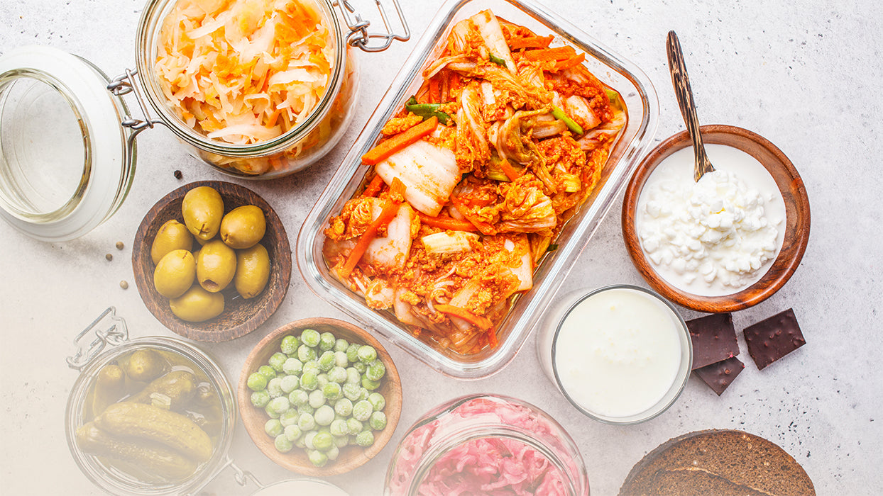 Gefaesse mit Oliven fermentiertes Gemuese Salz Erbsen Gurken Kimchi